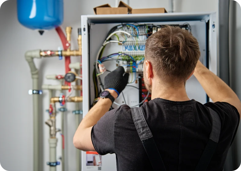 Man fixing electrical components in cabinet