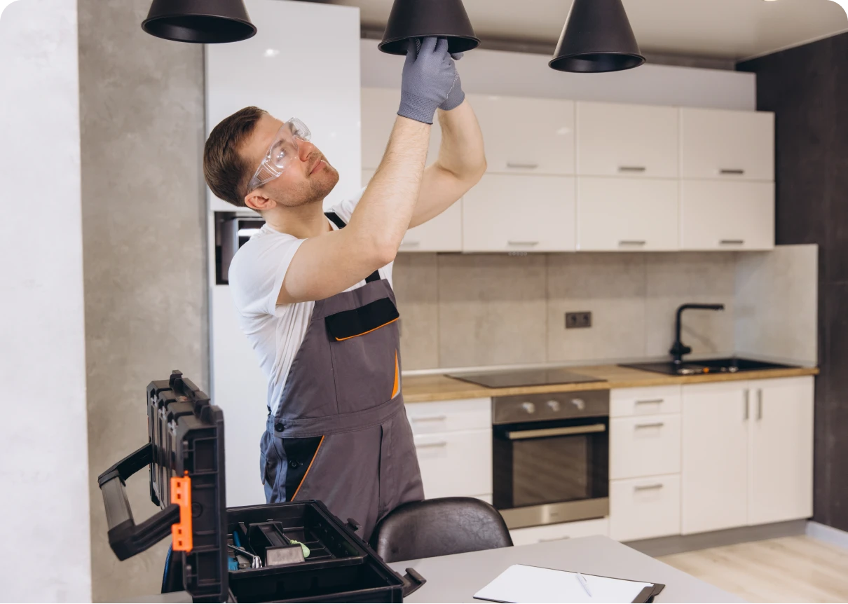 Electrician installing kitchen light fixture