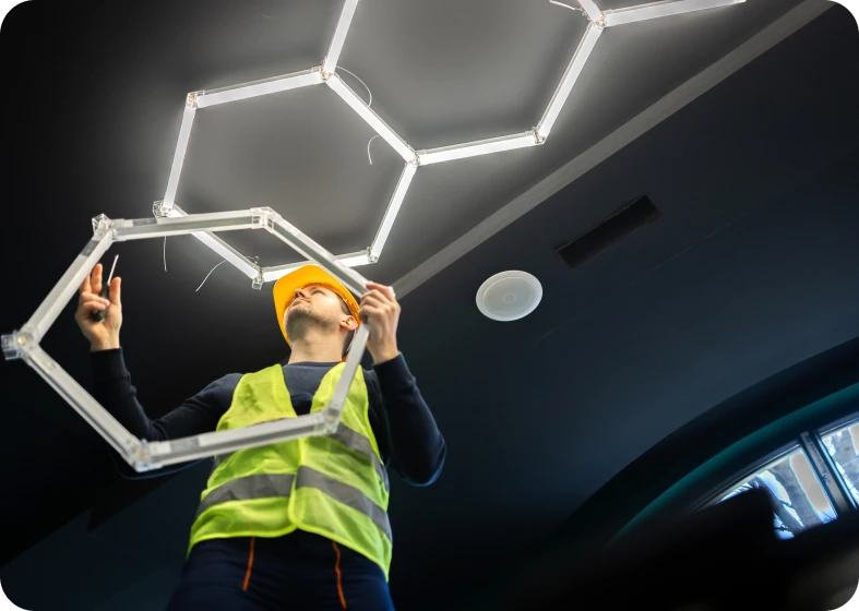 Worker inspecting hexagonal light fixture